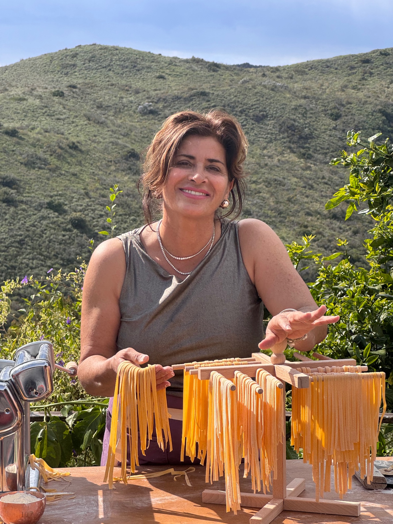 Fiona with colorful strands of handmade pasta outdoors