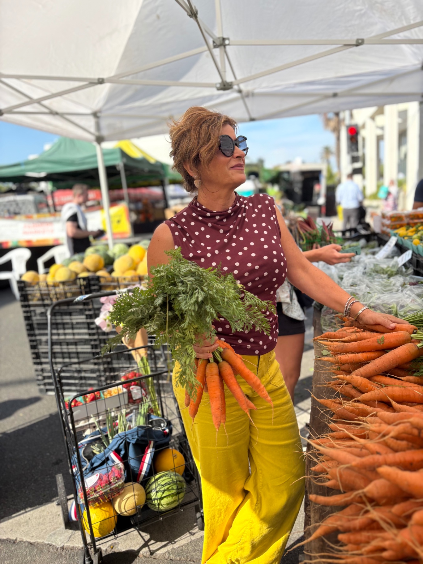 Fiona choosing carrots at the farmers market
